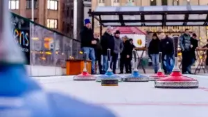 Koe-On-Ice-Menschen-bei-einer-spannenden-Partie-Eisstockschiessen-als-Weihnachtsfeier